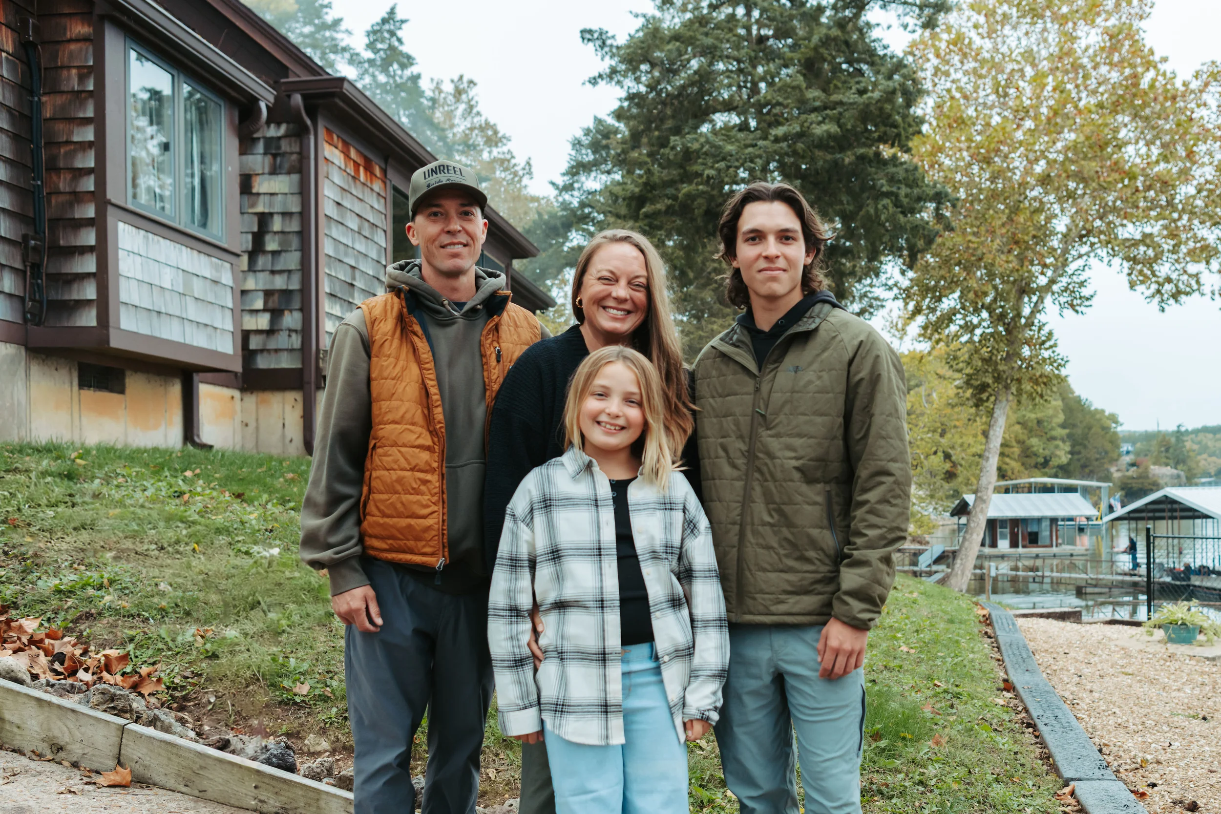 family of four mom dad brother and sister smiling for the camera